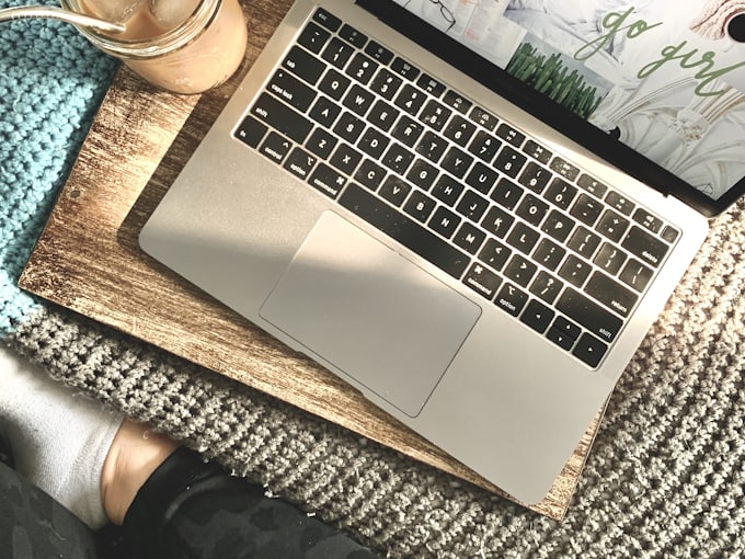 A laptop and coffee on a cosy knitted blanket